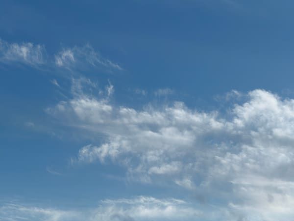 Delicate white cloud trails across a blue sky.