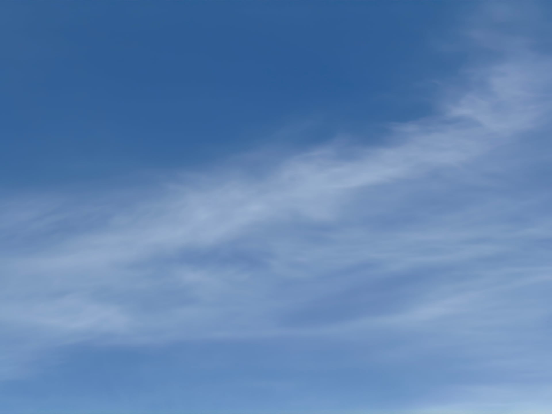 Thin, pale clouds drifting across a blue sky.