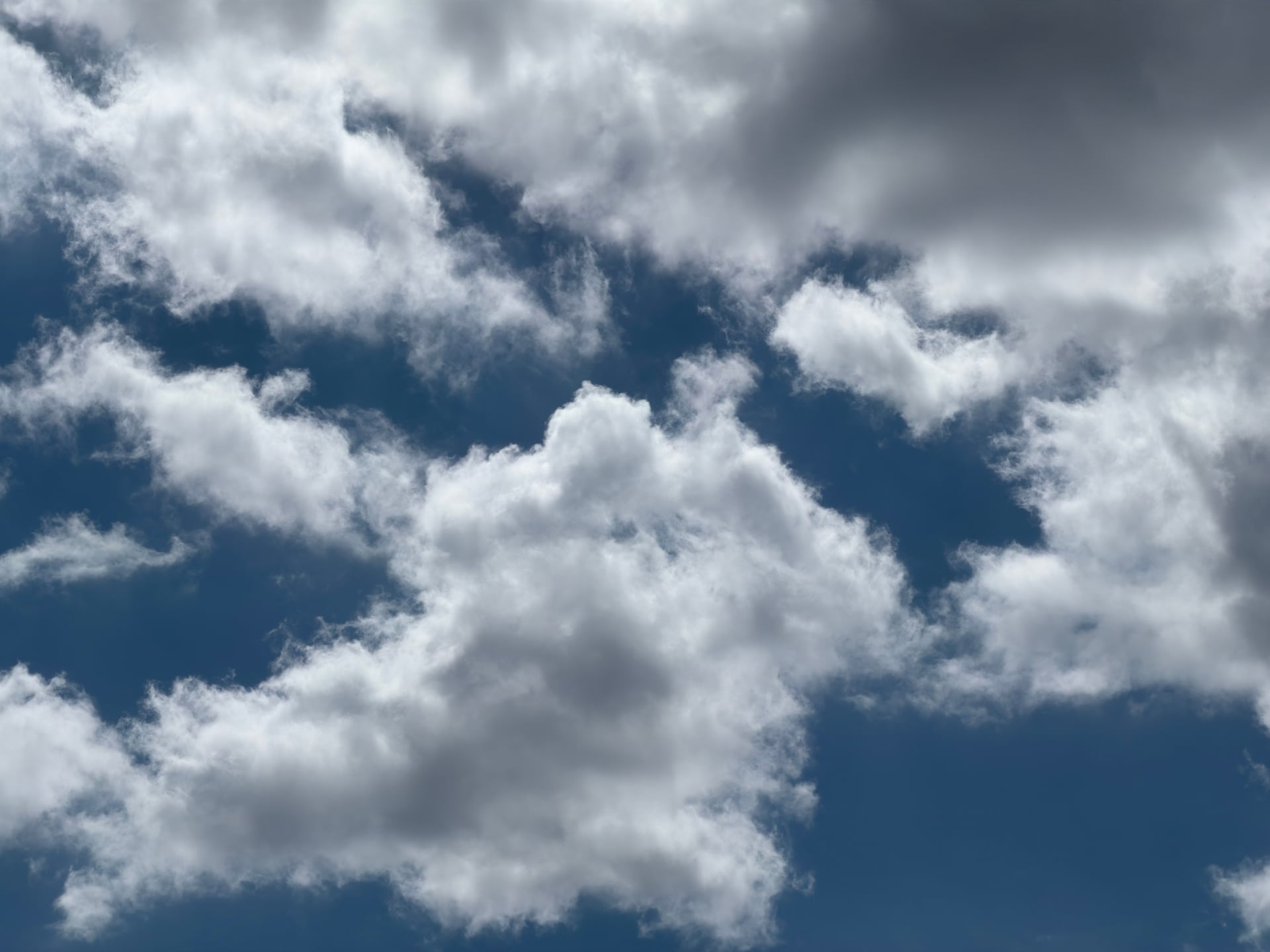 Layers of sunlit cumulus clouds with blue sky between them.