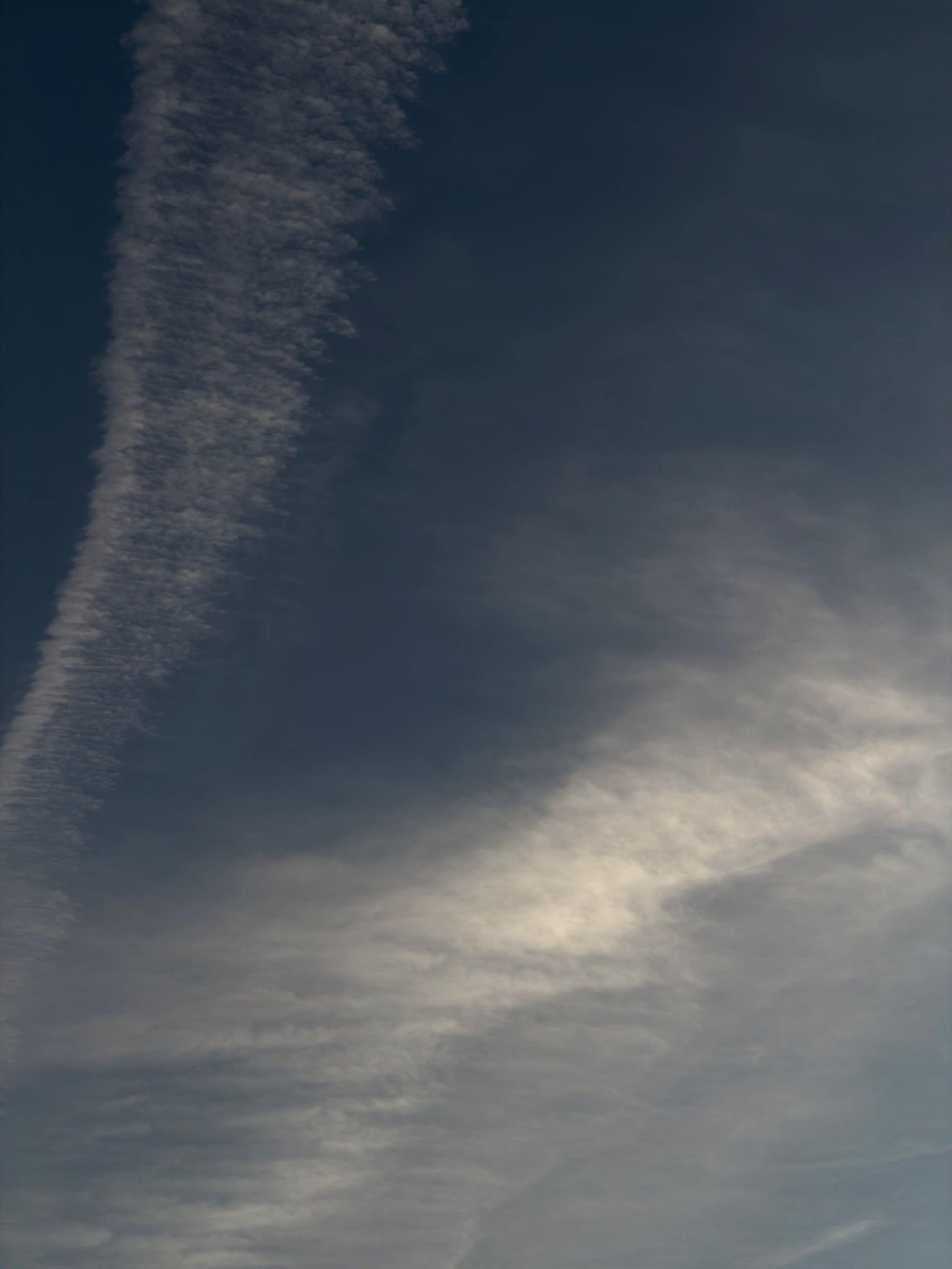 A curved ribbon of cloud above soft evening light.